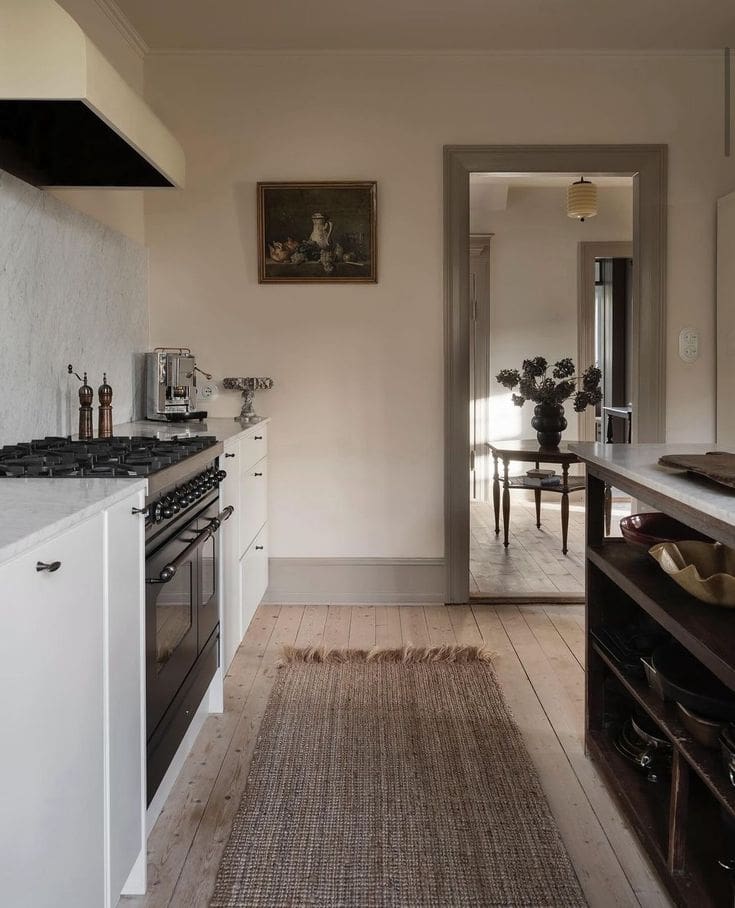 Minimal and warm classic kitchen, scandinavian influence, moody vintage painting, jute rug