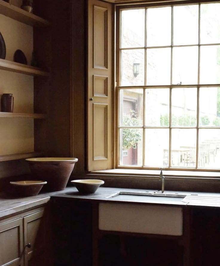 British inspired simple kitchen with terracotta bowls and natural light