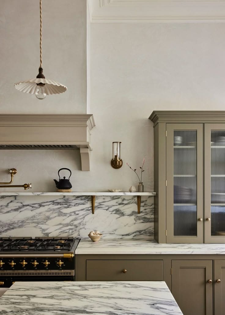 Minimal kitchen with green brown cabinets, corchia marble, and devol pendant by And Studio